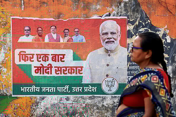 A woman walks past an election campaign poster of the Bharatiya Janata Party (BJP) featuring their leader and India's Prime Minister Narendra Modi (R), along a street in Varanasi on March 24, 2024, ahead of the country's upcoming general elections. - Representative Image/Getty Images