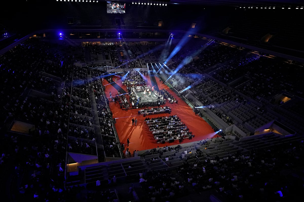 Francois Mori/AP : Mathieu Bauderlique of France and Russia's Igor Mikhalkin exchange blows during their light-heavyweight bout on the central court Philippe Chatrier at the Roland Garros tennis stadium, in Paris, Friday, Sept. 10, 2021. The Roland Garros stadium will host some boxing and tennis competitions during the Paris 2024 Olympic Games.