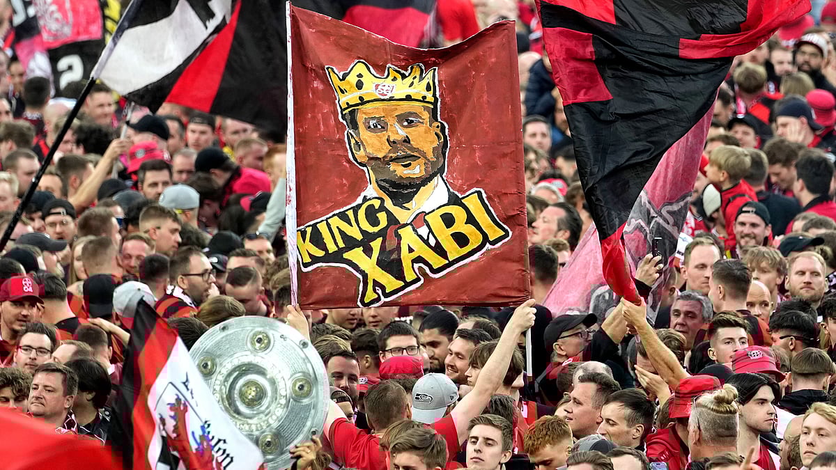 Martin Meissner/AP : Fans celebrate after Bayer Leverkusen won the German Bundesliga title beating Werder Bremen in Leverkusen, Germany on April 14, 2024.