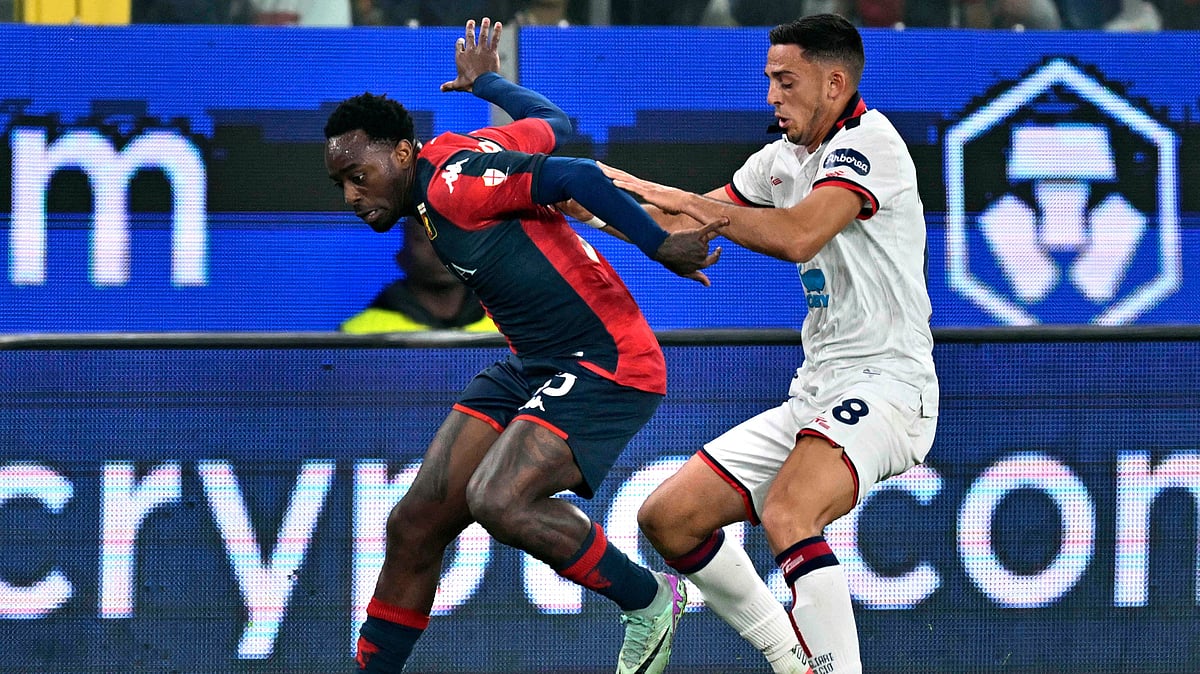 AP : 
During a Serie A soccer match, Genoa's Ridgeciano Haps and Cagliari's Nahitan Nandez vie for possession of the ball.