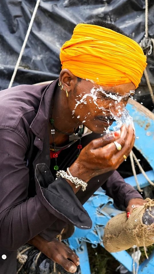 AP : A man splashes water on hot summer afternoon to cool himself |