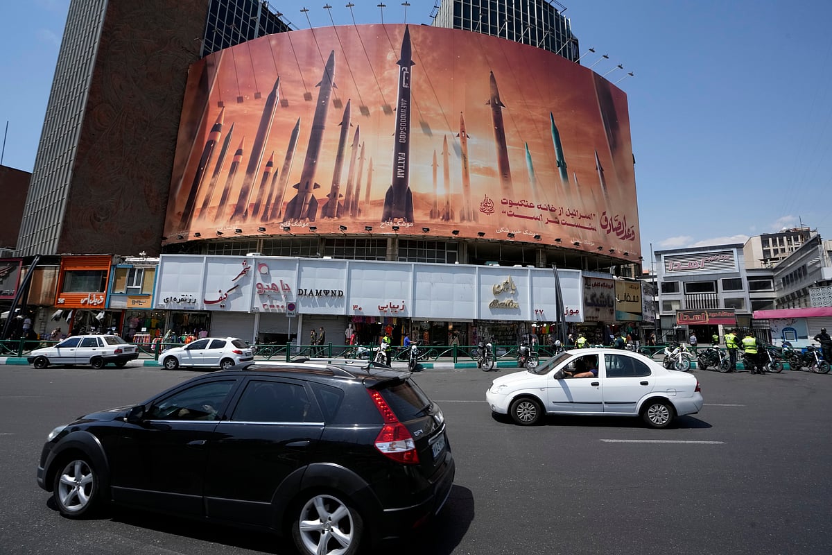 Vehicles drive past an anti-Israeli banner showing missiles being launched, in a square in downtown Tehran, Iran (representative image) - null