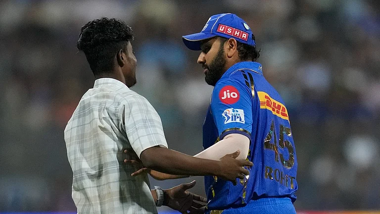 A pitch invader try to hug Mumbai Indians' Rohit Sharma during the Indian Premier League cricket match between Mumbai Indians and Rajasthan Royals in Mumbai, India, Monday, April. 1, 2024. - AP/Rafiq Maqbool