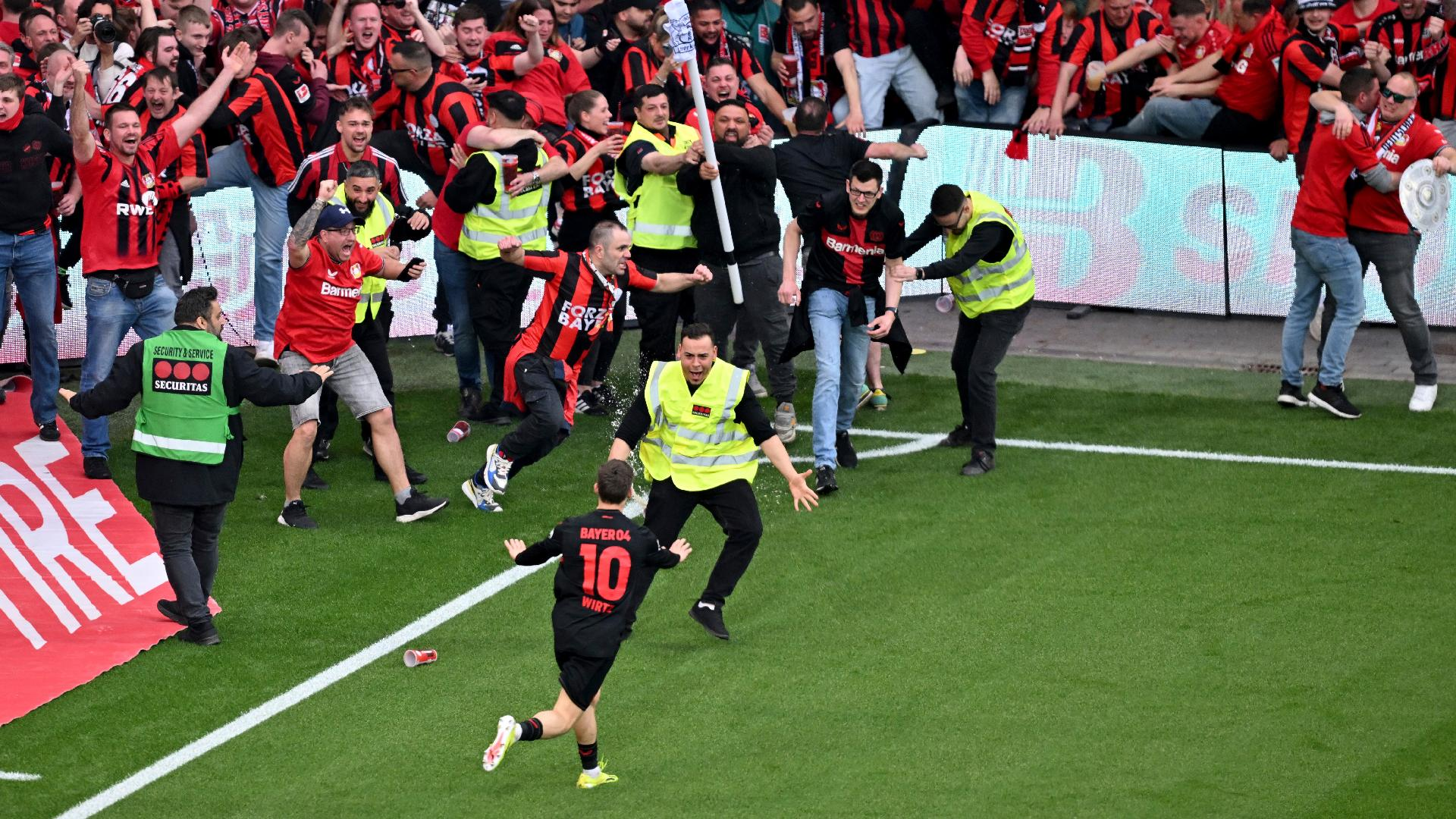 Leverkusen’s Florian Wirtz calms down fans and security personnel as he celebrates after scoring his side’s fourth goal. - David Inderlied/dpa via AP