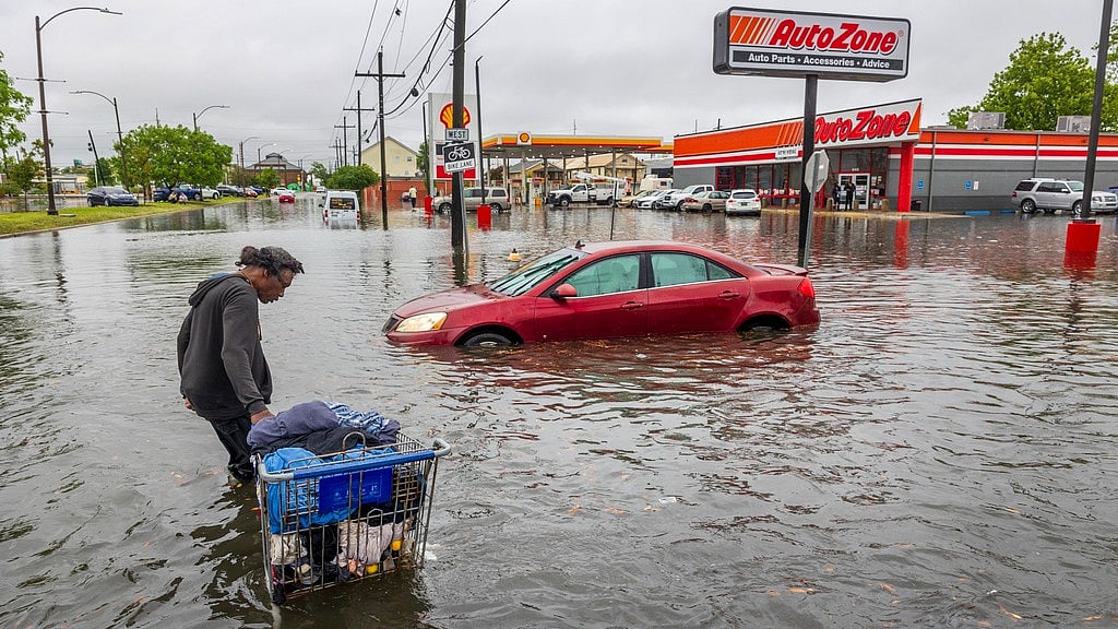 AP : People carry their belongings down a flooded Broad Street in New Orleans, during a severe rainstorm on Wednesday, April 10, 2024.
