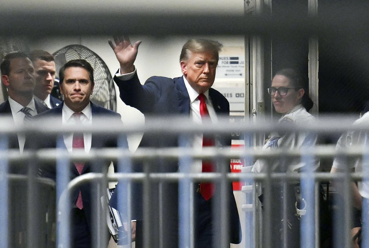 Former President Donald Trump waves as he returns to the courtroom after a break at Manhattan Criminal Court - AP