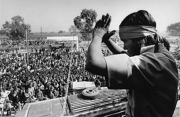 Sondeep Shankar/Getty Images : Indian rights activist, bandit and politician Phoolan Devi (1963 - 2001) greets her well wishers standing on the roof of a bus she was travelling in to the surrender at Bhind, Madhya Pradesh, India - February 1983
