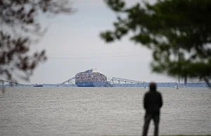 AP : A person views from Fort McHenry a container ship as it rests against the wreckage of the Francis Scott Key Bridge.