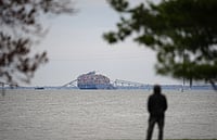 AP : A person views from Fort McHenry a container ship as it rests against the wreckage of the Francis Scott Key Bridge. 