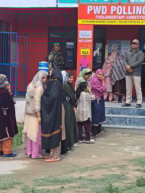 Voters queue up outside a polling station in Kashmir