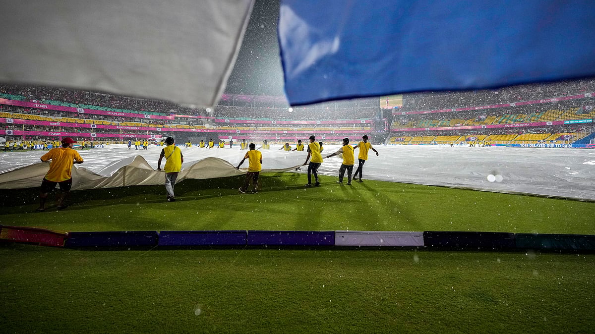 AP Photo/Anupam Nath : Ground staff pull covers as the rain delays the Indian Premier League cricket match between Rajasthan Royals and Kolkata Knight Riders in Guwahati.