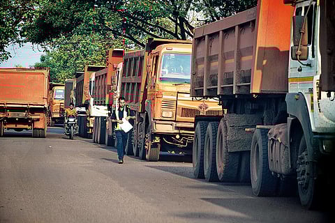Trucks carrying extracted iron ore lined up on the main road in Etapalli, south Gadchiroli