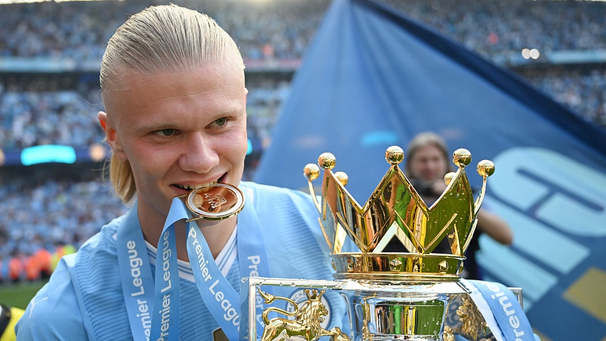 Erling Haaland celebrates with the Premier League trophy on Sunday. - null