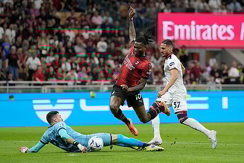 Rafael Leao, centre, dribbles past Cagliari's goalkeeper