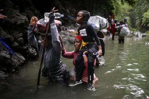 Haitian migrants wade through water as they cross the Darien Gap from Colombia to Panama in hopes of reaching the U.S., Tuesday, May 9, 2023. The image was part of a series by Associated Press photographers Ivan Valencia, Eduardo Verdugo, Felix Marquez, Marco Ugarte Fernando Llano, Eric Gay, Gregory Bull and Christian Chavez that won the 2024 Pulitzer Prize for feature photography.