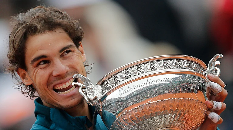 Spain's Rafael Nadal bites the trophy after winning against compatriot David Ferrer in three sets 6-3, 6-2, 6-3, in the final of the French Open tennis tournament, at Roland Garros stadium in Paris, Sunday June 9, 2013. - AP