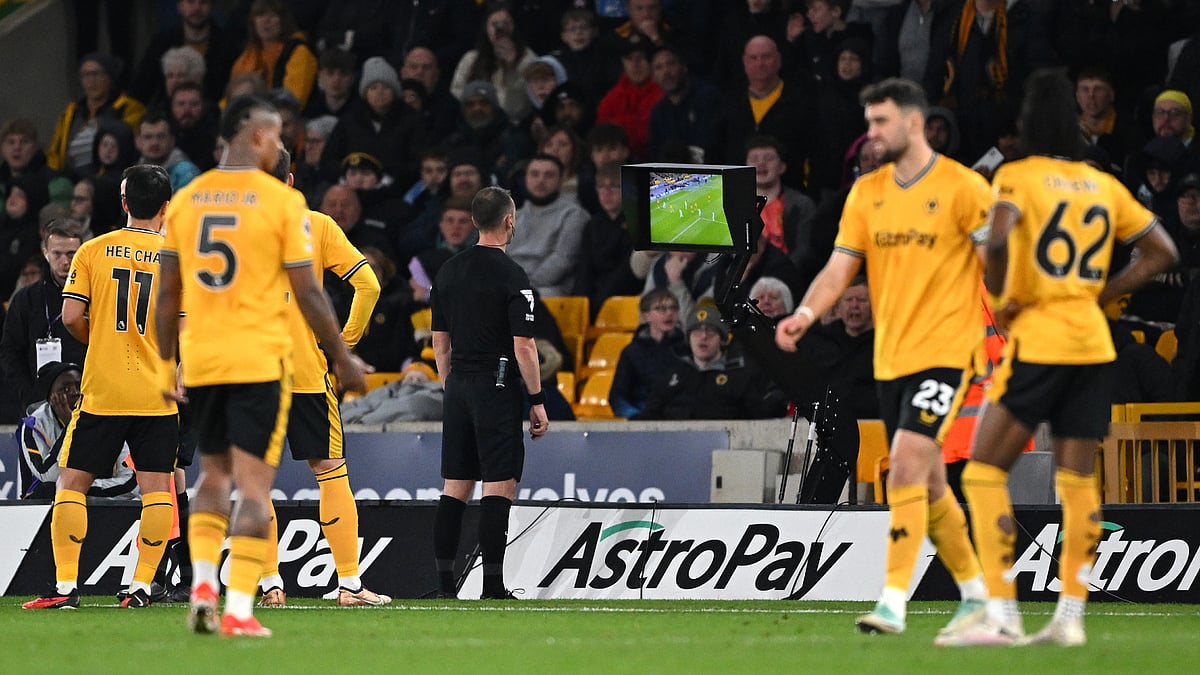 Stuart Attwell goes to the VAR monitor to disallow a Wolves goal against Bournemouth. - null