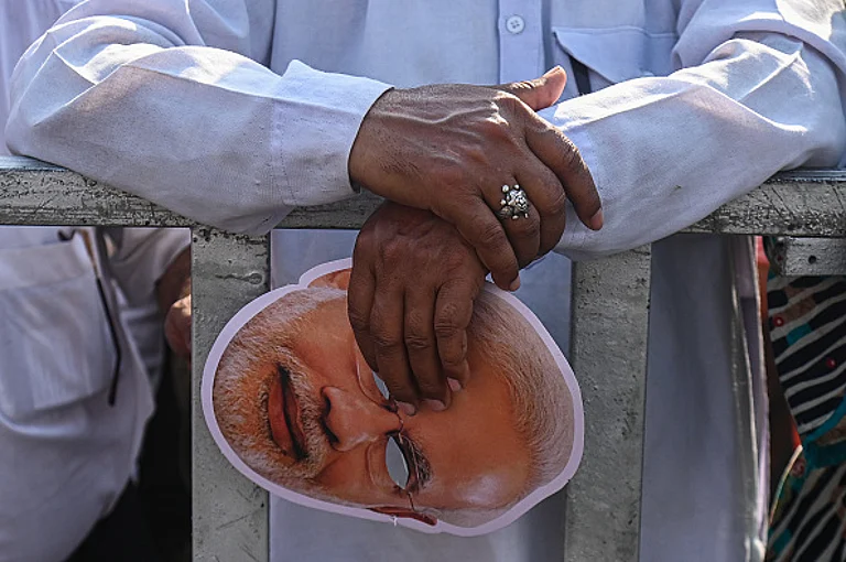 A man is holding a face mask of Indian Prime Minister Narendra Mod -  (Photo by Kabir Jhangiani Getty Images)