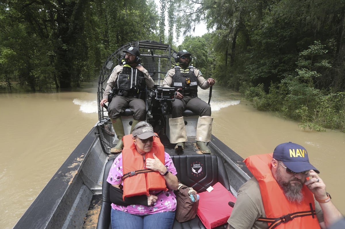AP : Texas Parks & Wildlife Department game wardens use a boat to rescue residents from floodwaters in Liberty County, Texas.