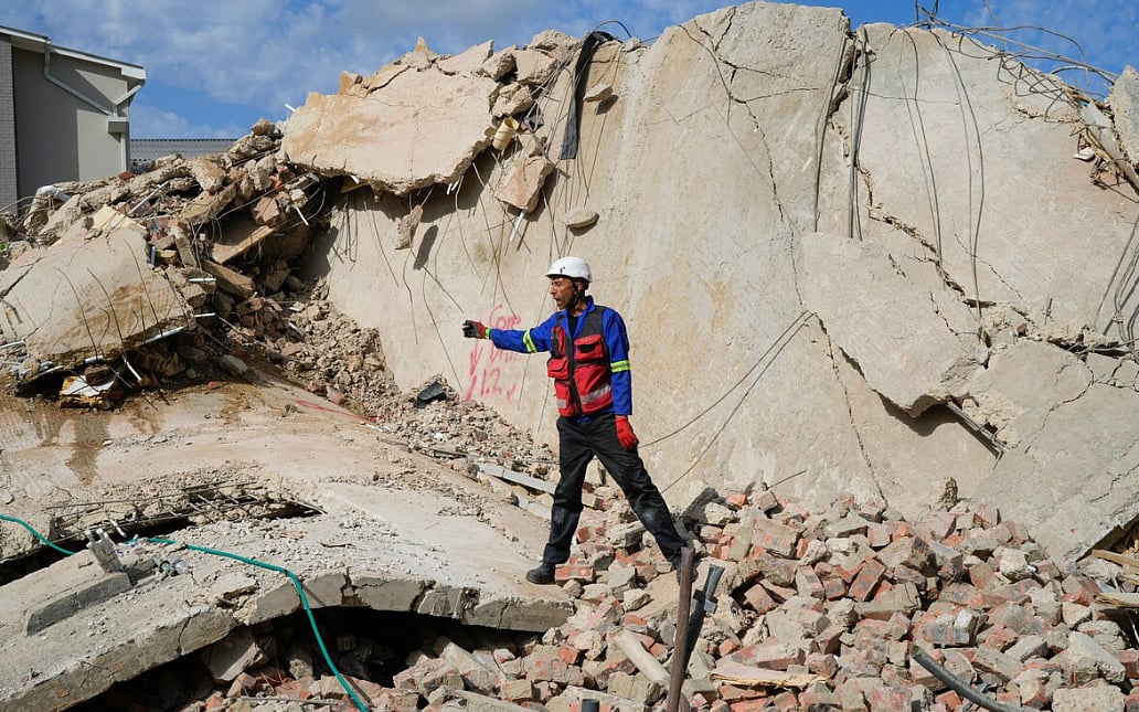 AP : Rescue workers search the site of a building collapse in George, South Africa, Wednesday, May 8, 2024. Rescue teams are searching for dozens of construction workers missing after a multi-story apartment complex collapsed in the coastal city have brought out more survivors as the operation entered a second night of desperate work to find anyone alive in the mangled wreckage.