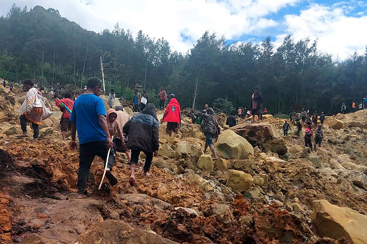 AP : People crossing over the landslide debris in Yambali village.