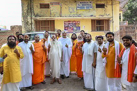 'Sadhus' show their ink-marked fingers after casting votes