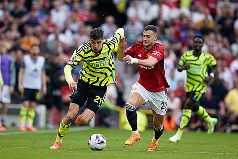 Kai Havertz, left, challenges for the ball with Diogo Dalot