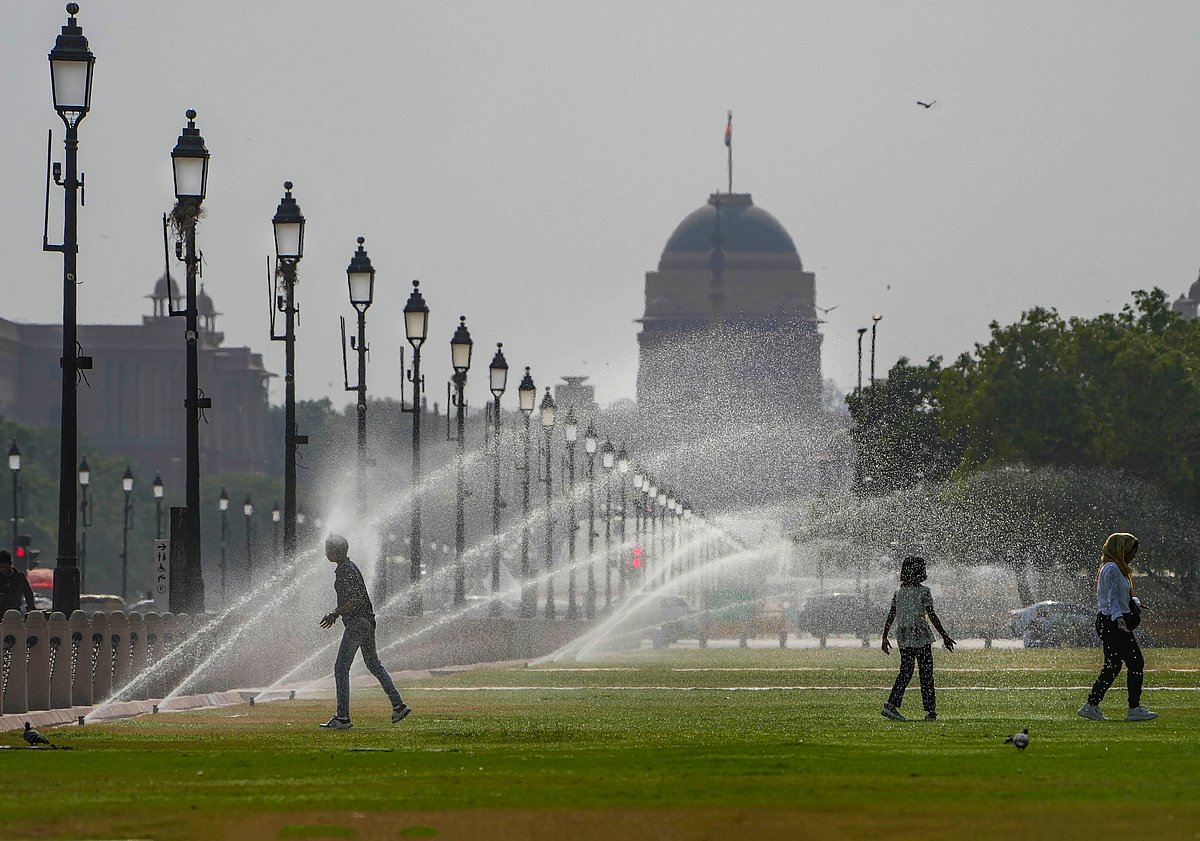PTI : A boy stands facing a spray to beat the heat at Central Vista Lawns near India Gate , in New Delhi, Sunday, May 19, 2024. 