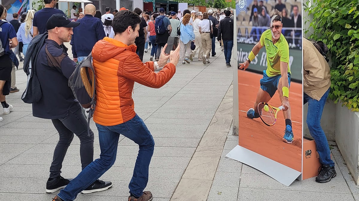 AP : A French fan poses with a life-sized cardboard cutout of Rafael Nadal next to Roland Garros main stadium, Tuesday, May 21, 2024 in Paris. The French Open tennis tournament start Sunday May 26th.