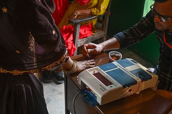An election official is putting ink on the finger of a woman who is casting her vote at a polling station during the third phase of the Indian General Elections in Hathras district, Uttar Pradesh, India, on May 7, 2024 - Kabir Jhangiani/NurPhoto via Getty Images
