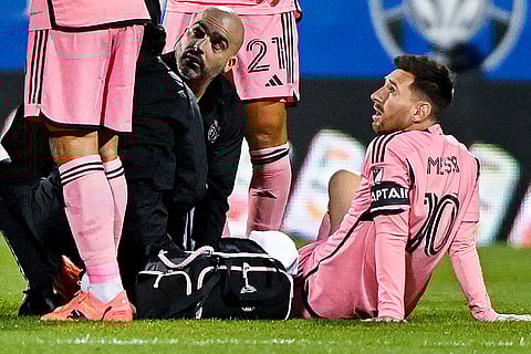 Injured Lionel Messi with team trainers