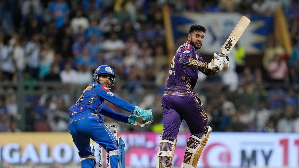 AP Photo/Rajanish Kakade : Kolkata Knight Riders' Venkatesh Iyer plays a shot as Mumbai Indians' Ishan Kishan watches during the Indian Premier League cricket match between Mumbai Indians and Kolkata Knight Riders in Mumbai.