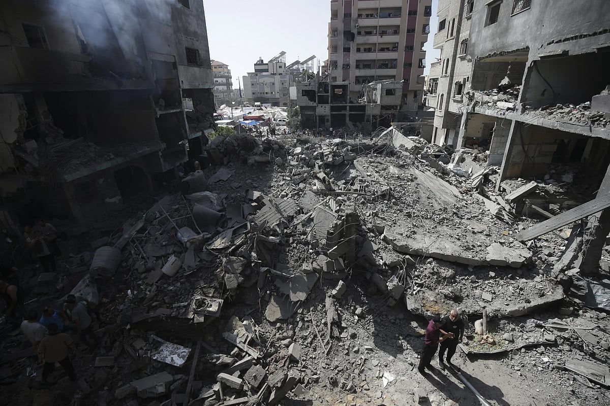 AP : Palestinians look at the aftermath of the Israeli bombing in Nuseirat refugee camp |