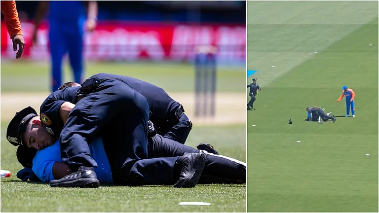 A pitch invader being handled by security staff - AP and X