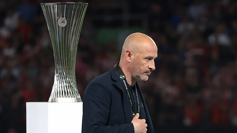 Vincenzo Italiano walks past the Europa Conference League trophy with a silver medal for a second straight year. - null