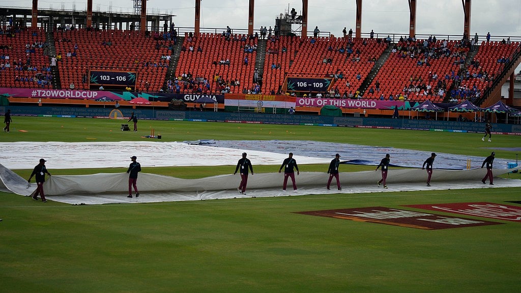 AP/Ramon Espinosa : Groundsmen move the covers after wet outfield delayed the toss for the ICC Men's T20 World Cup second semifinal cricket match between England and India at the Guyana National Stadium in Providence, Guyana, Thursday, June 27, 2024.

