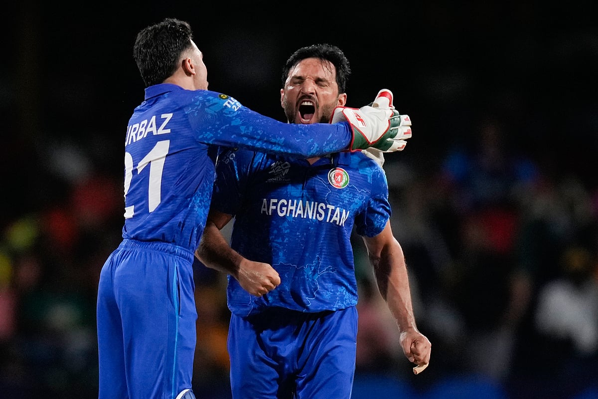 (AP Photo/Ramon Espinosa) : Afghanistan's Rahmanullah Gurbaz congratulates teammate Gulbadin Naib, right, after taking the wicket of Australia's Tim David during the men's T20 World Cup cricket match between Afghanistan and Australia at Arnos Vale Ground, Kingstown, Saint Vincent and the Grenadines, Saturday, June 22, 2024. 