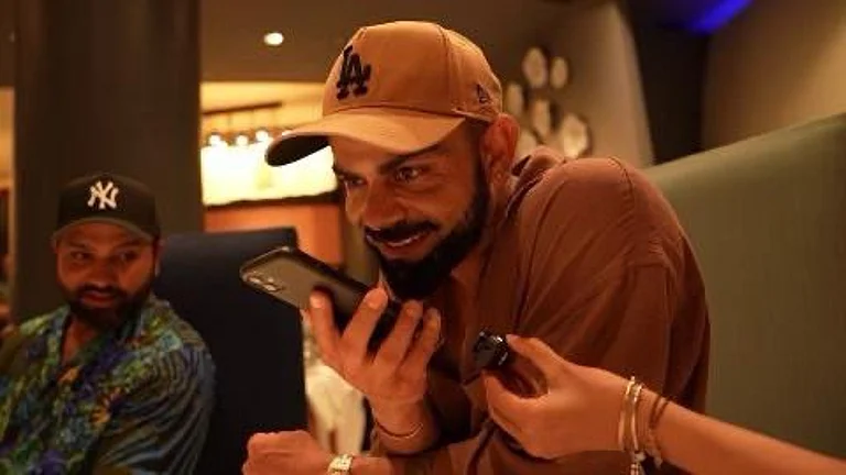 Prime Minister Narendra Modi wishing Virat Kohli on phone, as Rohit Sharma watches on after India won the ICC T20 World Cup 2024 trophy in Barbados. - X/Narendra Modi