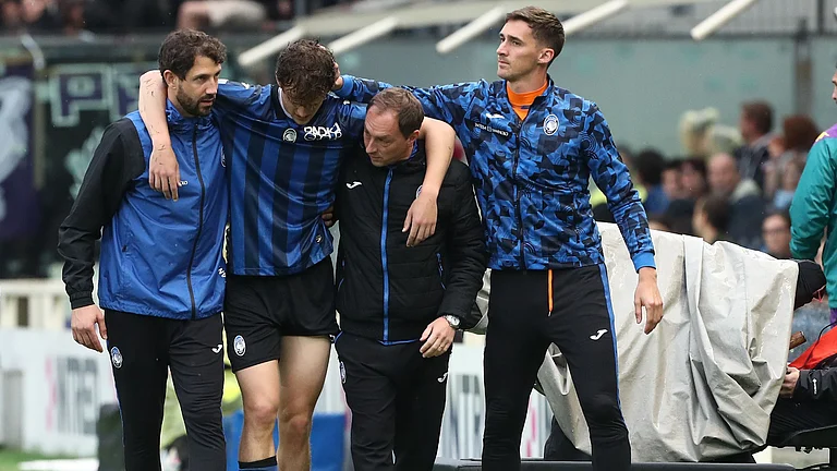 Giorgio Scalvini is helped from the field by Atalanta's medical staff - null