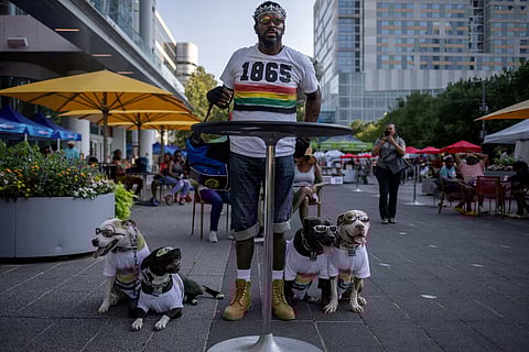 A man with his pets wearing juneteenth-themed t-shirt.