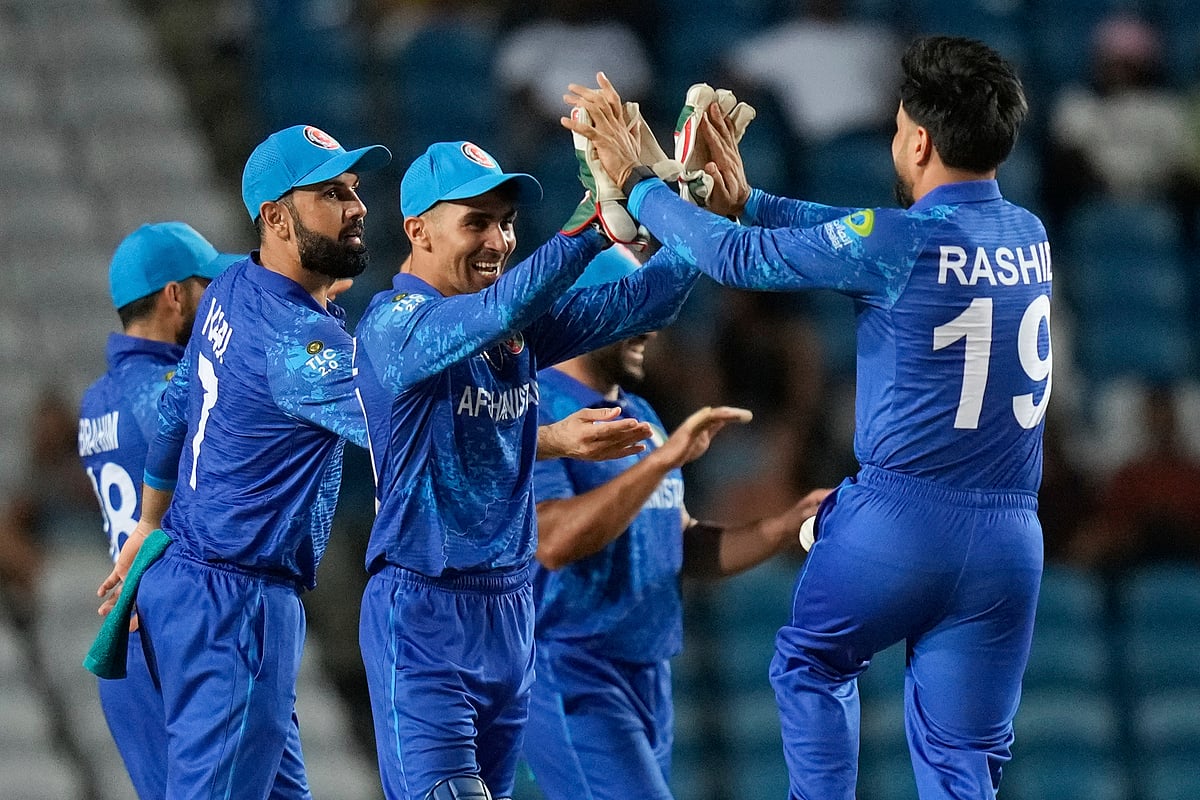 Afghanistan's wicket keeper Rahmanullah Gurbaz, second from left, celebrates with captain Rashid Khan the dismissal of Papua New Guinea's Lega Siaka during an ICC Men's T20 World Cup cricket match at Brian Lara Cricket Academy in Tarouba, Trinidad and Tobago, Thursday, June 13, 2024.  - (AP Photo/Ramon Espinosa)

