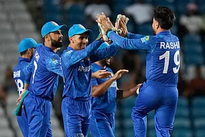 (AP Photo/Ramon Espinosa)
: Afghanistan's wicket keeper Rahmanullah Gurbaz, second from left, celebrates with captain Rashid Khan the dismissal of Papua New Guinea's Lega Siaka during an ICC Men's T20 World Cup cricket match at Brian Lara Cricket Academy in Tarouba, Trinidad and Tobago, Thursday, June 13, 2024.