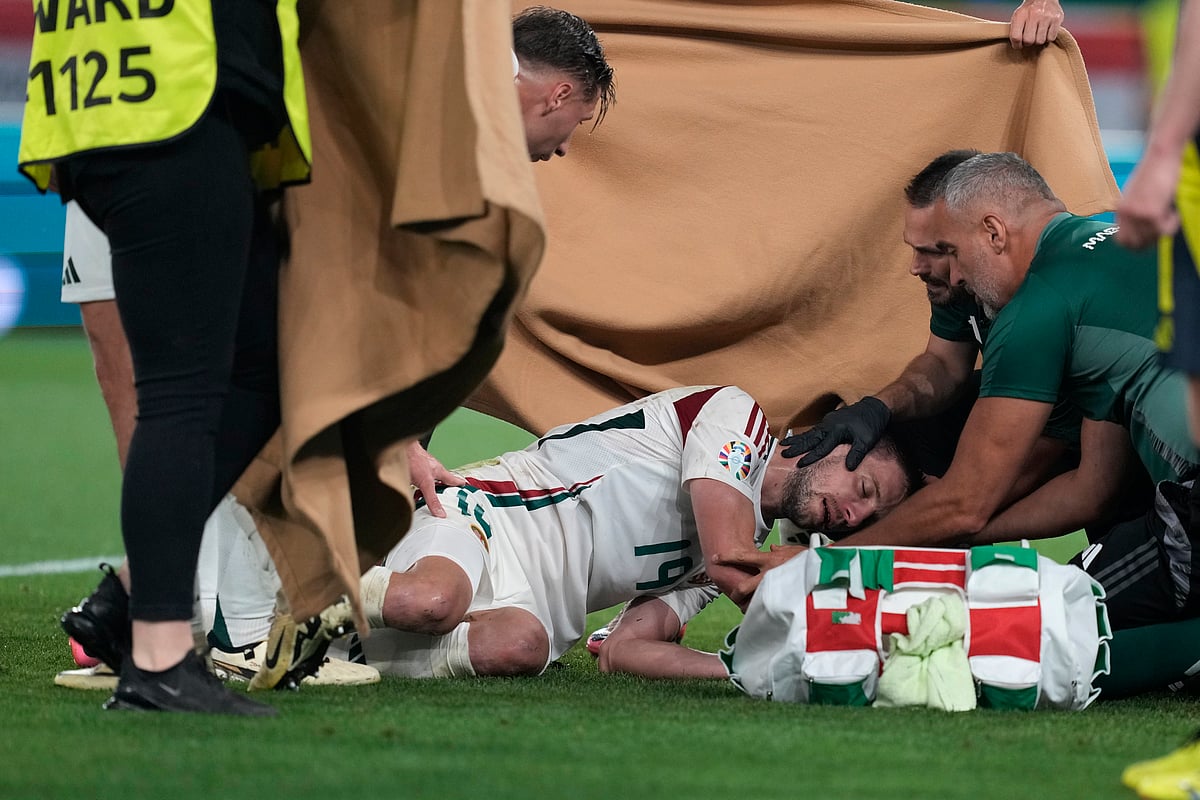 (AP Photo/Antonio Calanni) : Medical personnel treats Hungary's Barnabas Varga after he was injured during a Group A match between Scotland and Hungary at the Euro 2024 soccer tournament in Stuttgart, Germany, Sunday, June 23, 2024. 