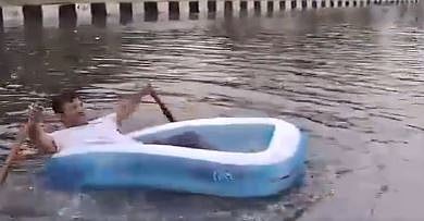 X/ Screengrab from ANI video : Delhi BJP councillor Ravinder Singh as seen rowing a boat on waterlogged street |