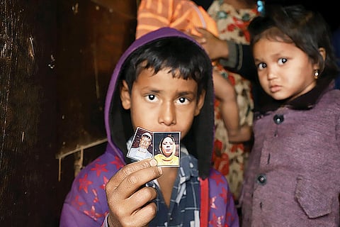 Children showing their detained parents’ photos