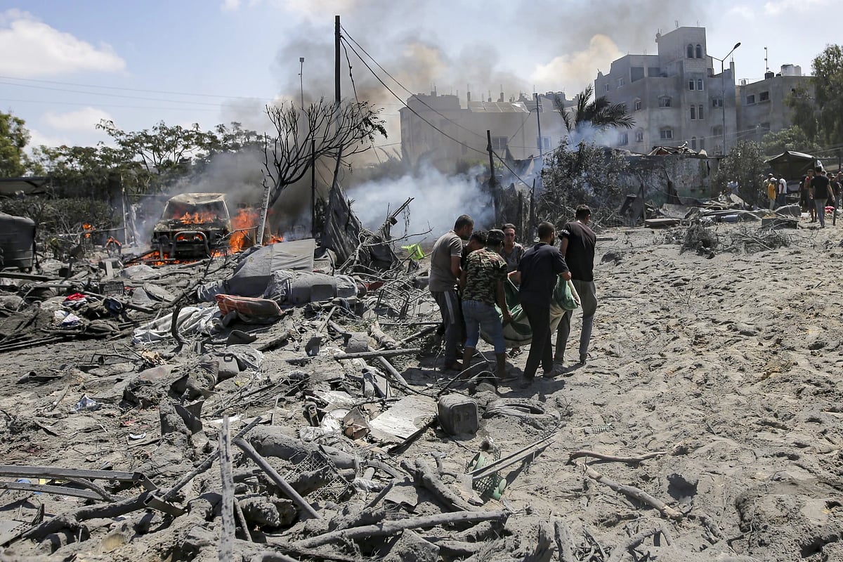AP : Palestinians evacuate a body from the site hit by Israeli bombing |