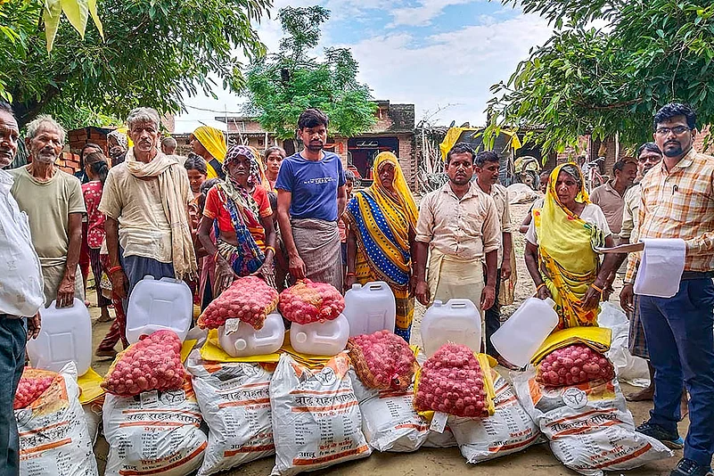 Flood affected people receive ration kits at Kilkili village, in Hardoi district.