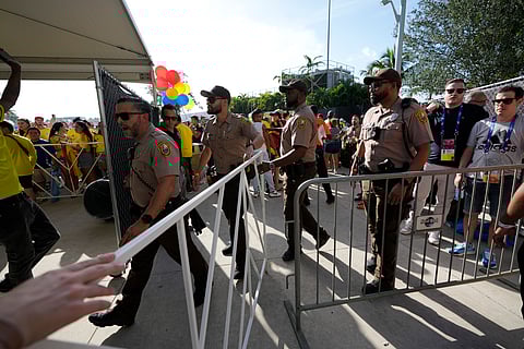 Policemen patrol the area as fans wait to enter at stadium prior to the Copa America final match between Argentina and Colombia Sunday, July 14, 2024, in Miami Gardens, Fla.