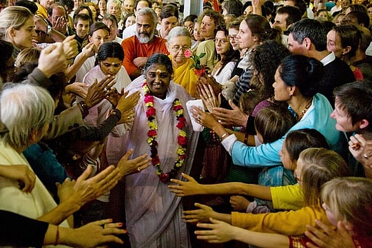 The Hugging Saint’s Global Reach And Local Controversies