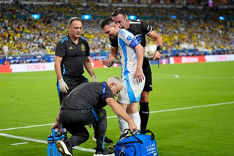 Lionel Messi of Argentina is treated by the staff medics in the final.